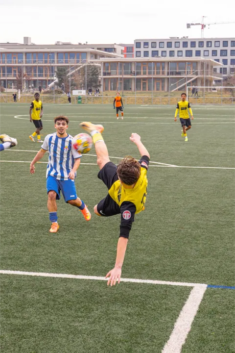Geste acrobatique d'un joueur tentant un retourné en plein match