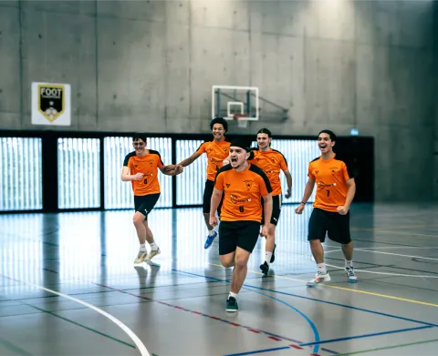 Match de futsal en salle, équipe en maillot orange