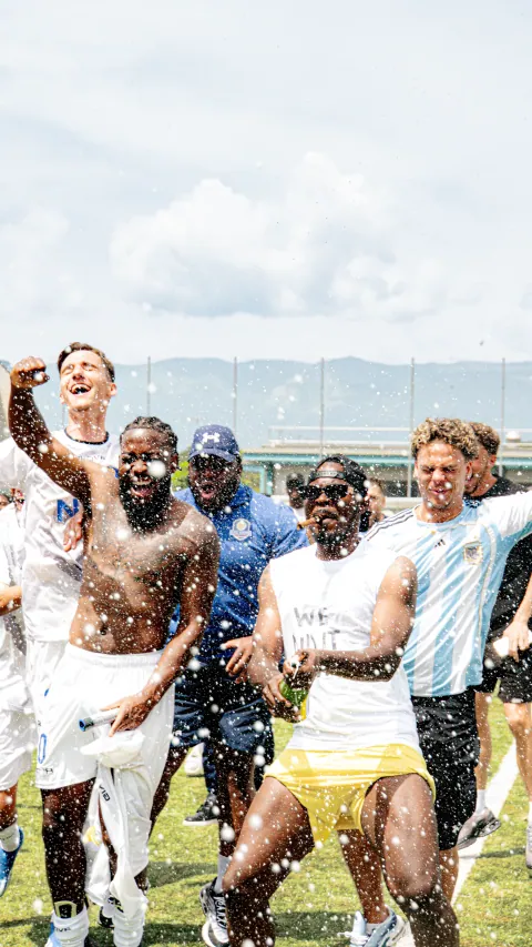 Célébration d'équipe arrosée au champagne après la victoire