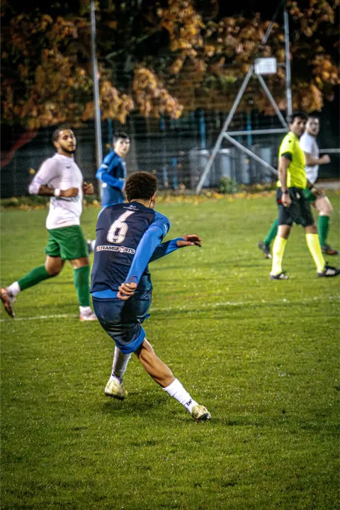 Volée d'un joueur en bleu lors d'un match en nocturne