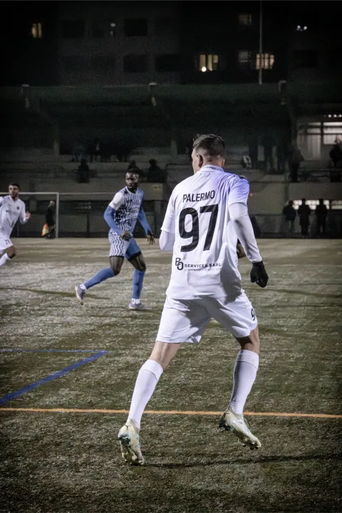 Joueur numéro 97 vu de dos pendant un match en nocturne