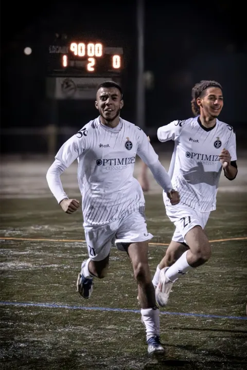 Joueurs en blanc célébrant un but en fin de match
