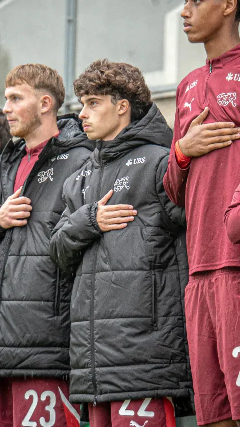 Joueurs alignés et recueillis avant le coup d'envoi