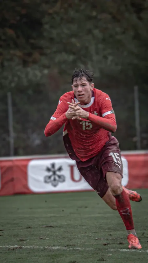 Course du numéro 15 en maillot rouge pendant le match