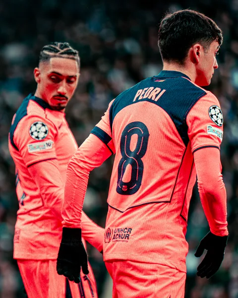 Pedri, numéro 8, de dos aux côtés de Raphinha lors de Newcastle – FC Barcelone