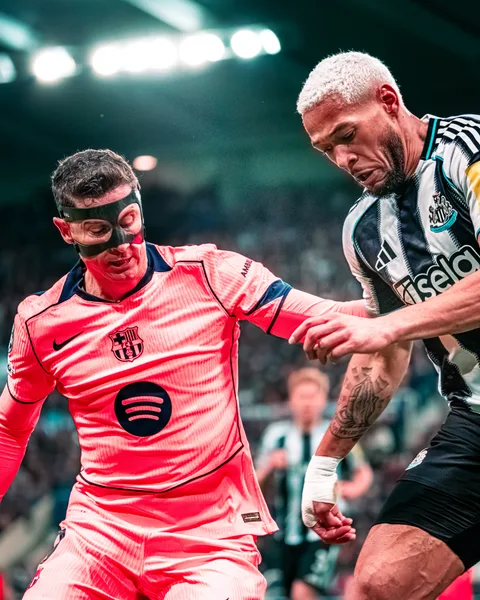Robert Lewandowski, masque de protection, au duel avec un joueur de Newcastle à St James' Park